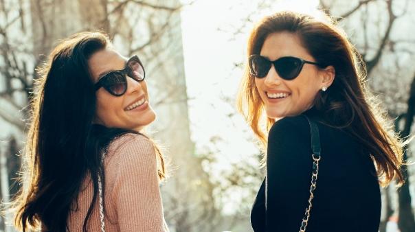 Two women wearing sunglasses and smiling

Description automatically generated