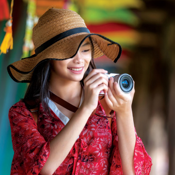 A person wearing a hat and holding a cameraAI-generated content may be incorrect.