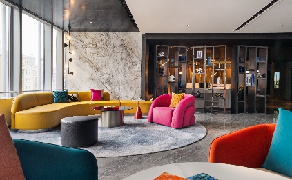 A room with a round rug and colorful chairs Description automatically generated